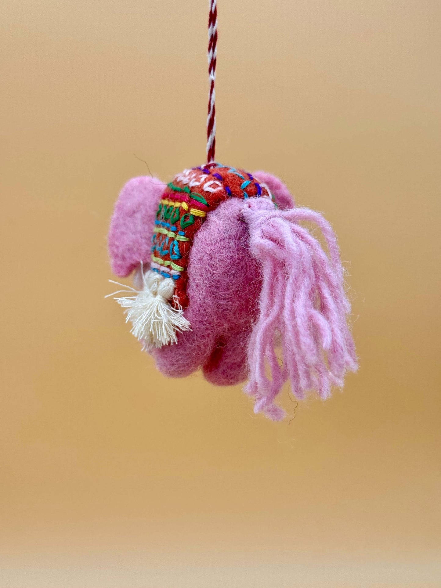 Handmade pink elephant felt keychain, featuring vibrant patterns and soft wool, perfect for decorative use.