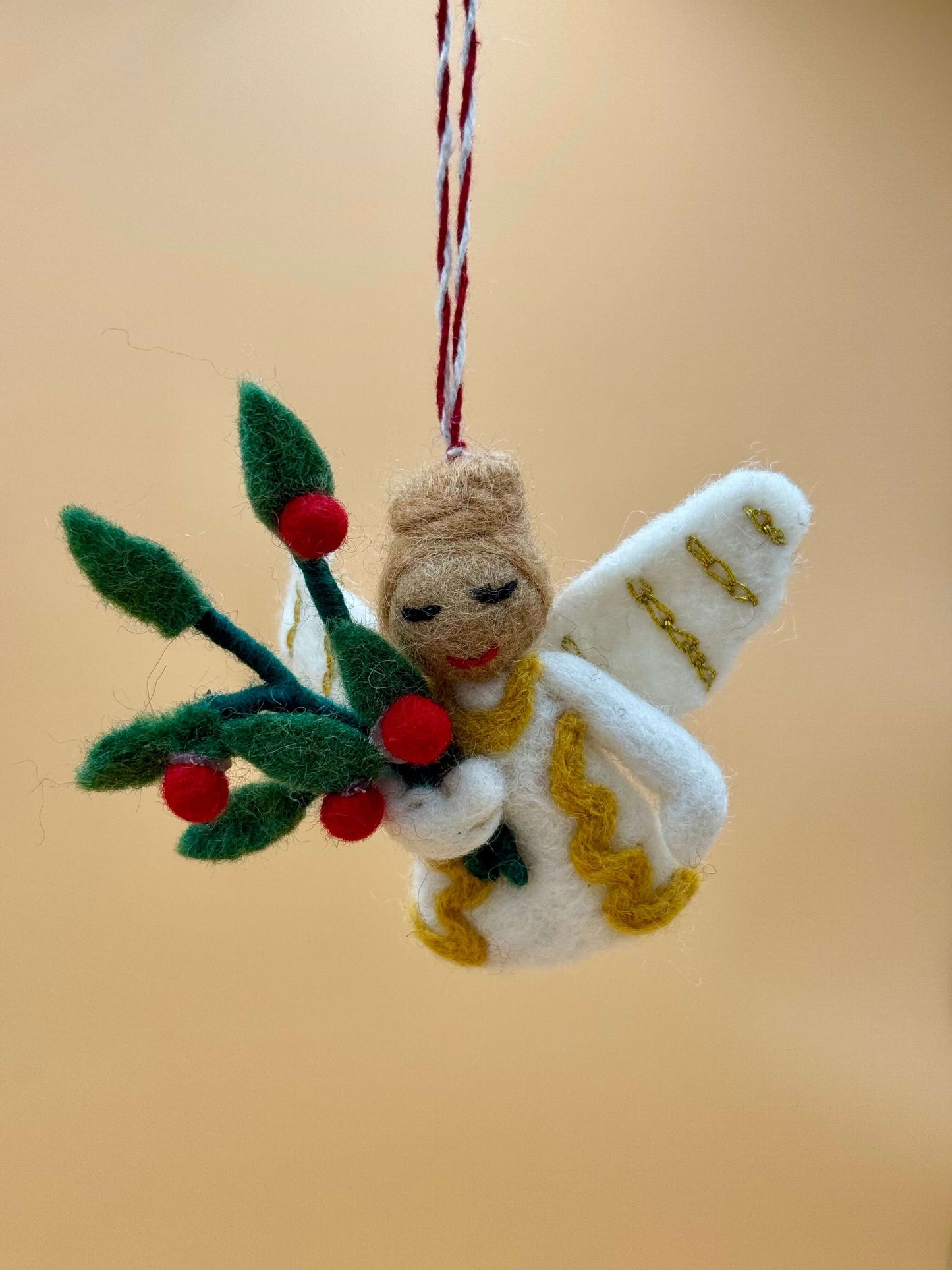 Handgemachter Filzanhänger Schlüsselanhänger Engel mit Blume in beigen, grünen, und roten Farben.