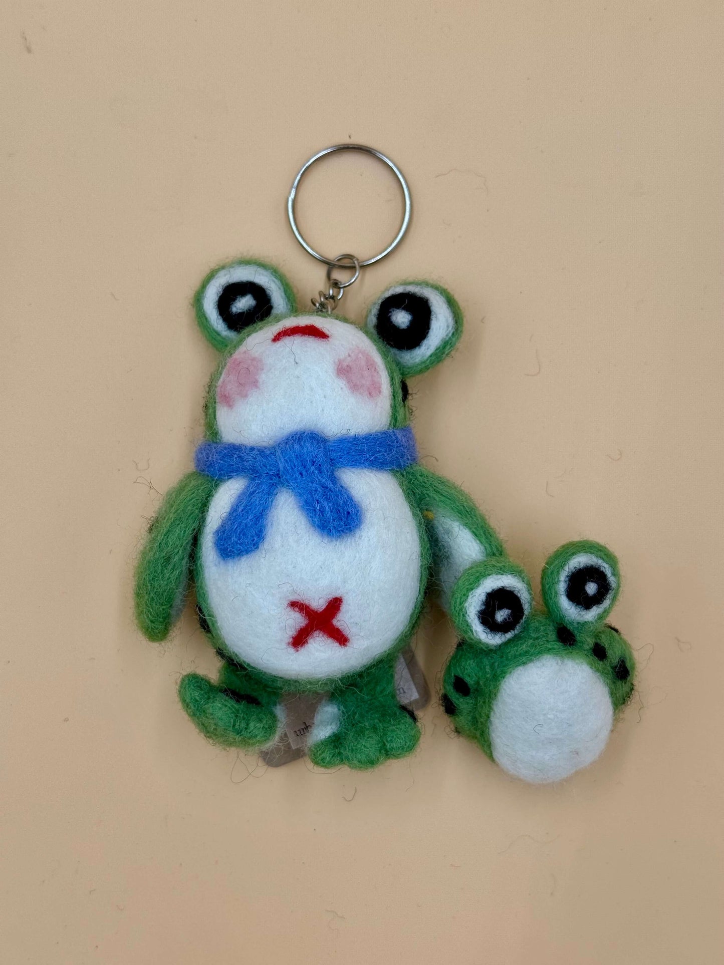 Handmade wool felt frog keychain featuring a frog and a baby frog, green, white, with a blue scarf, unique design.