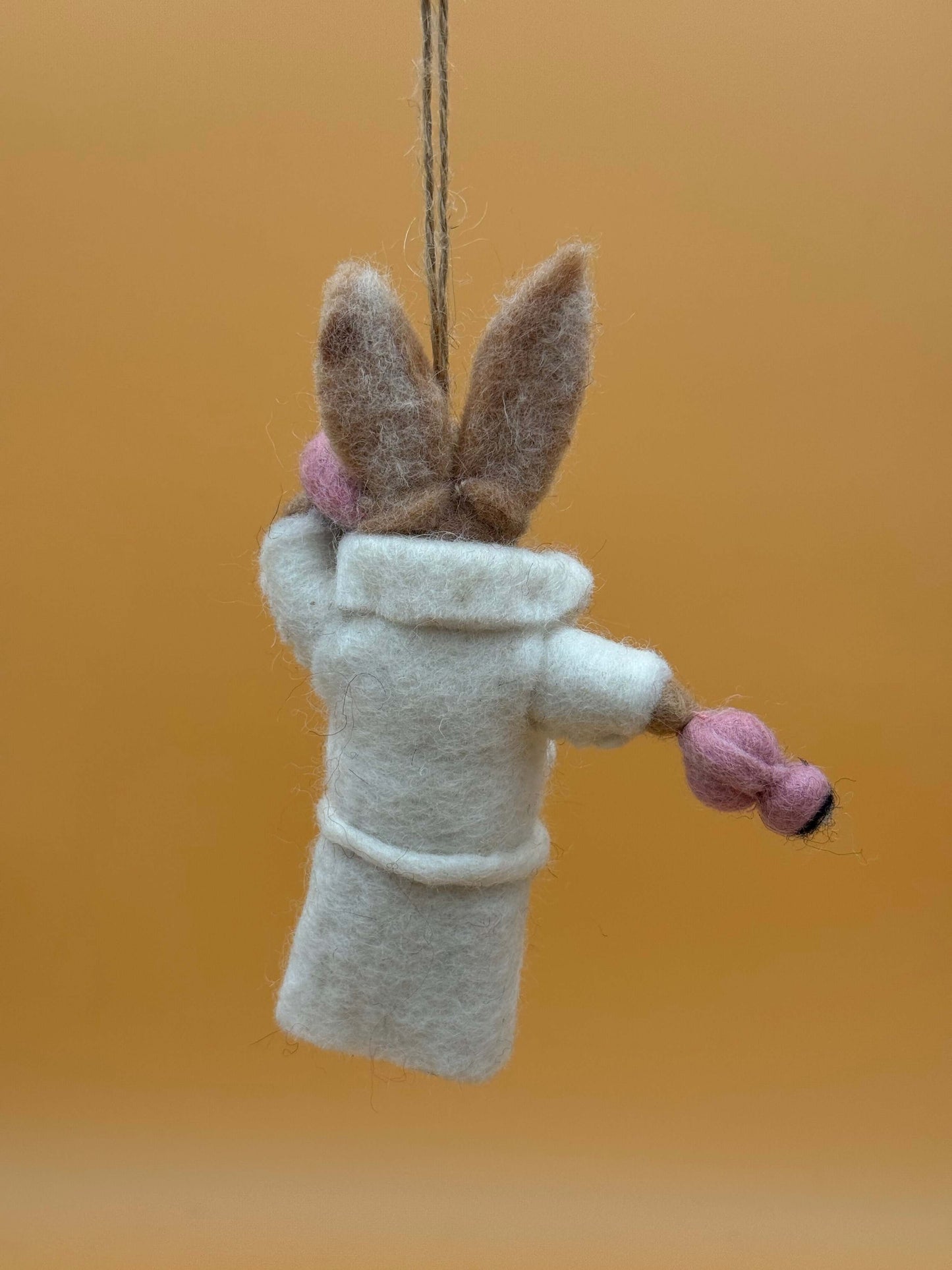 Filzanhänger Schlüsselanhänger Hase in Bademantel, handgemacht aus 100% Wolle, weiß mit rosa Details.