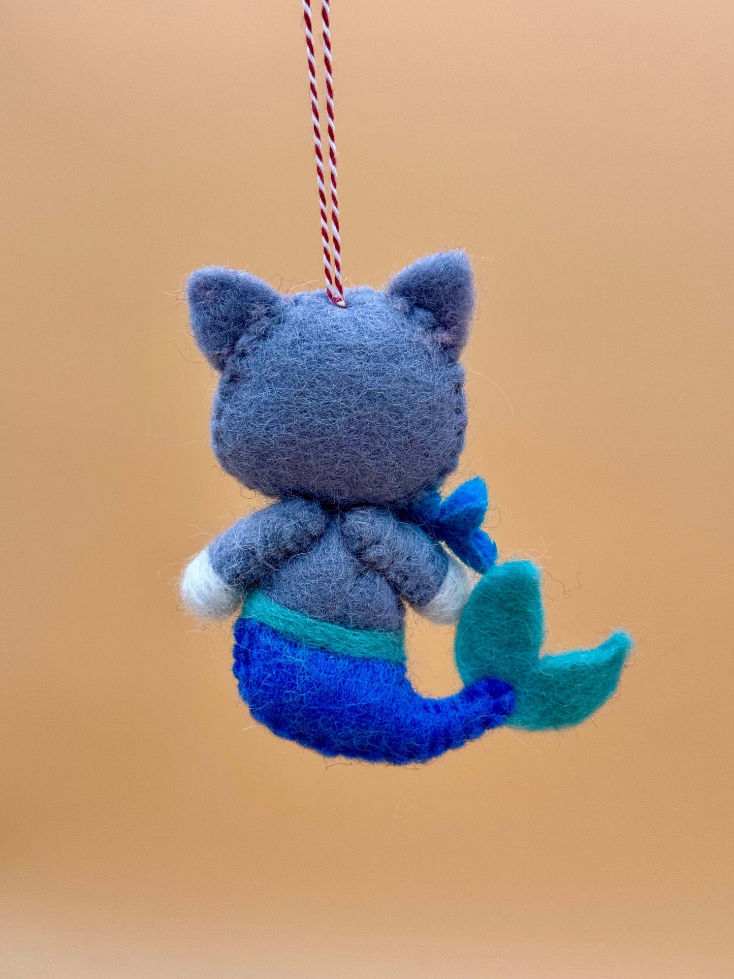 Handmade felt keychain featuring a mermaid cat with a fish in blue and pink colors, unique design.