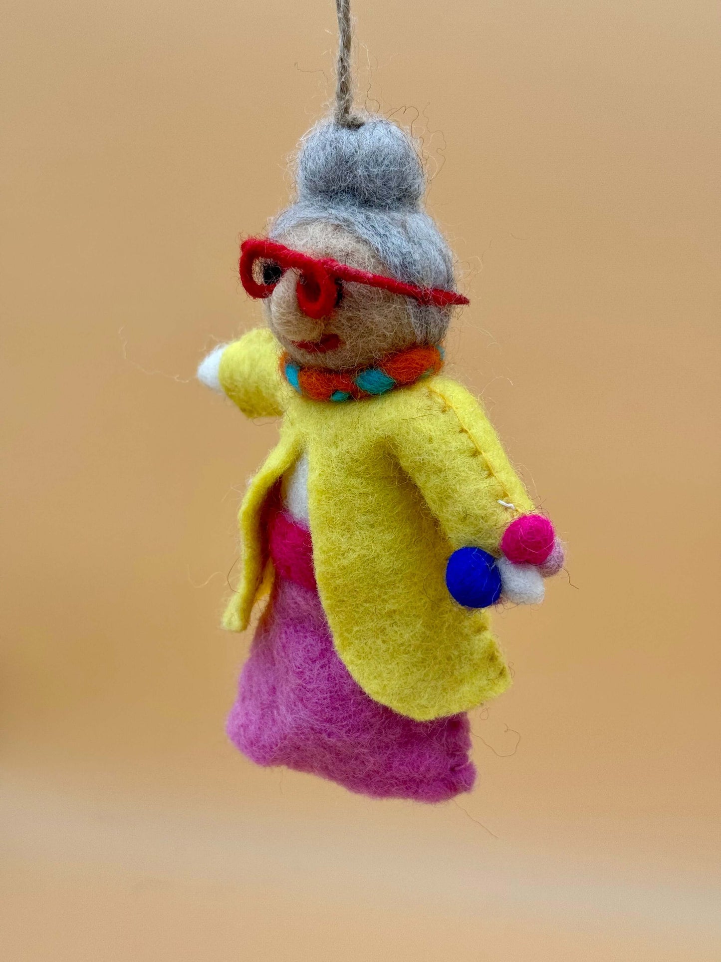 Handcrafted Filzanhänger Schlüsselanhänger in yellow and pink depicting a fashionable dancing grandmother wearing glasses.