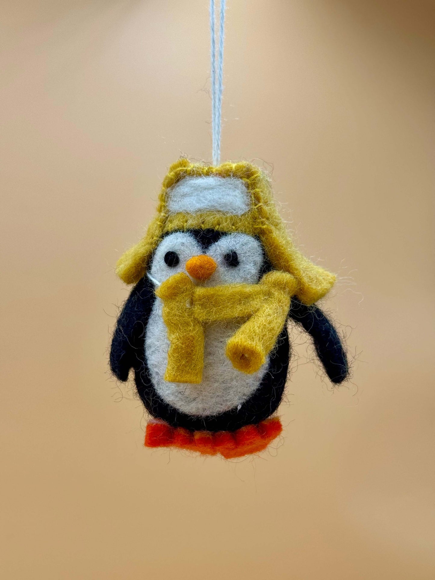Filzanhänger Schlüsselanhänger Pinguin mit Mütze und Schal, handgefertigt aus 100% Wolle in schwarz, weiß, gelb, orange.