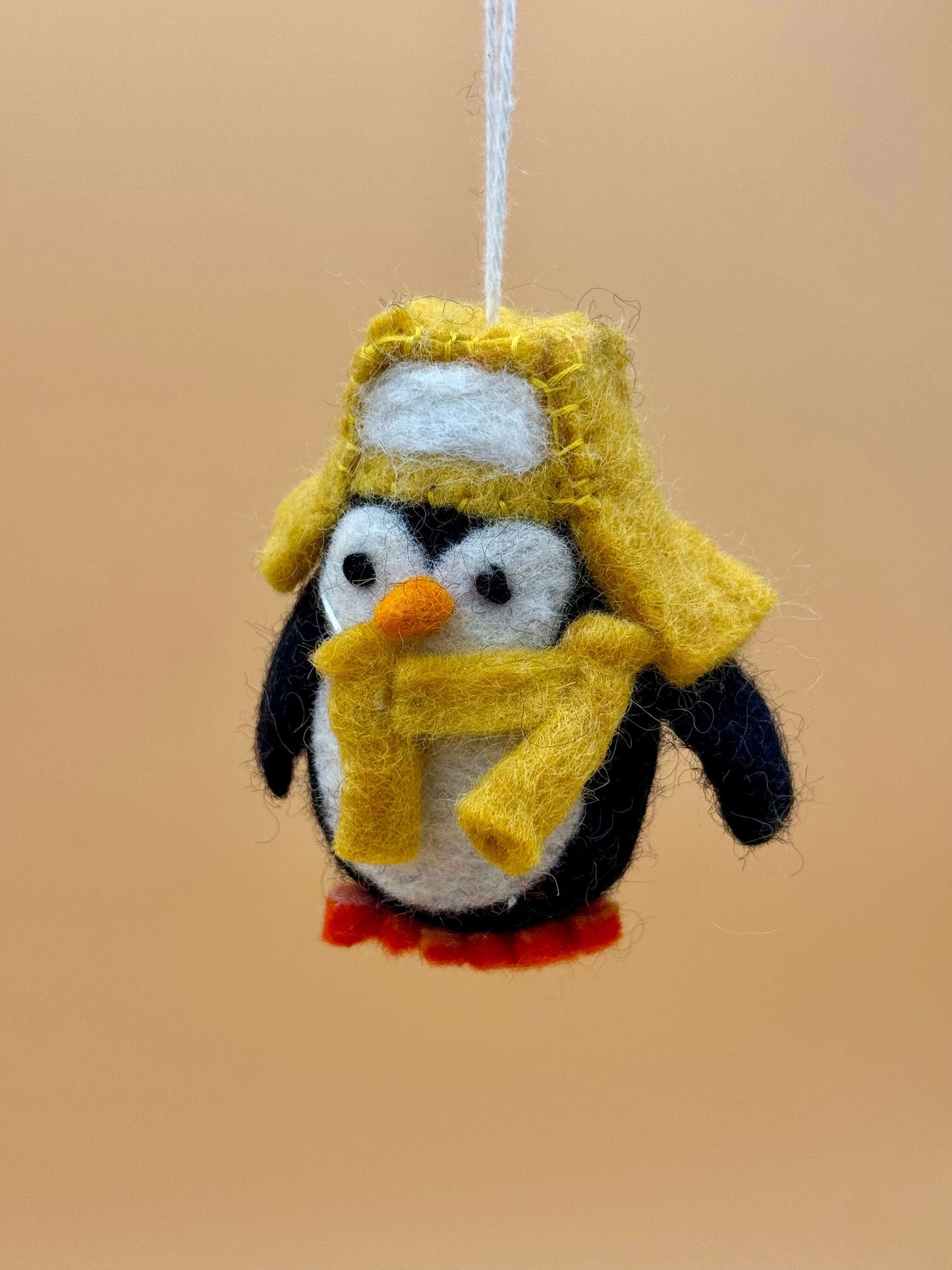 Filzanhänger Schlüsselanhänger Pinguin mit Mütze und Schal, handgemacht aus Wolle in schwarz, weiß, gelb, orange.