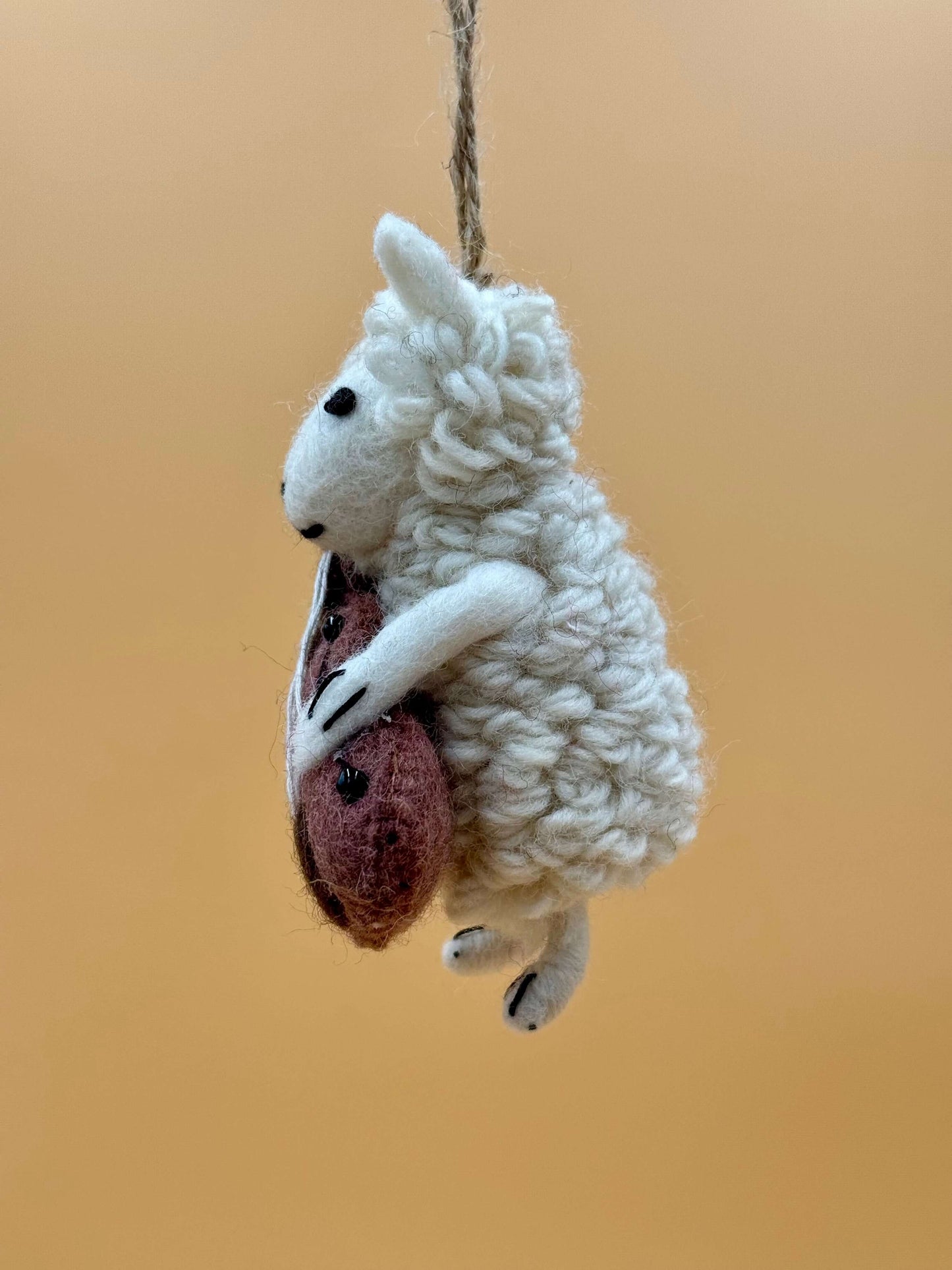 Filzanhänger Schlüsselanhänger Schaf spielt Cello, handgemacht aus 100% Wolle in weiß und braun.