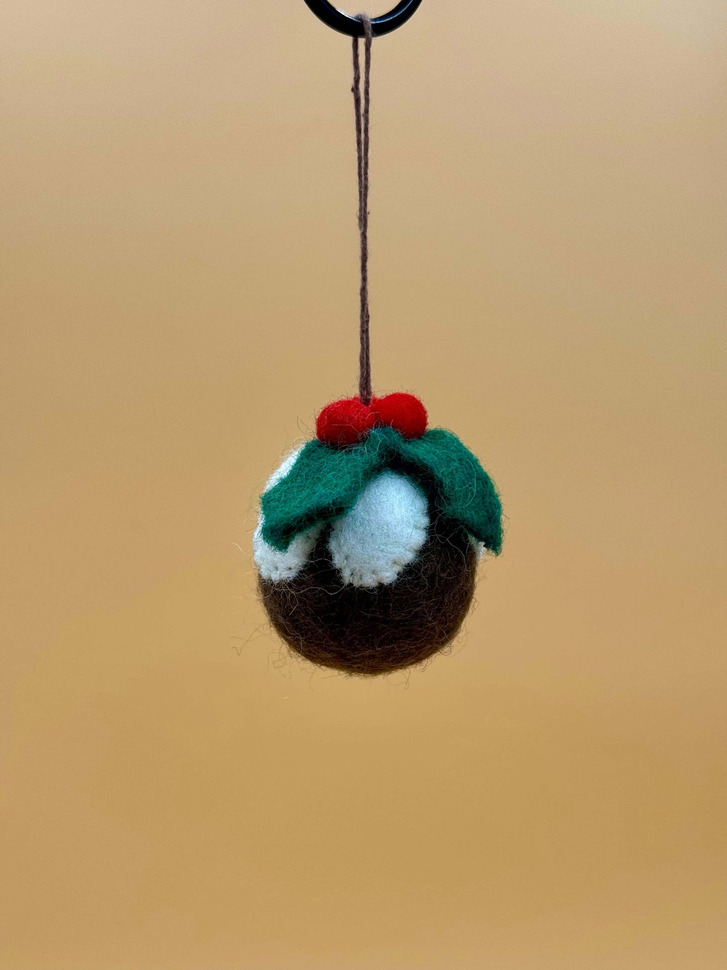 Handgemachter Filzanhänger Schlüsselanhänger in Form einer Weihnachtsbaum Kugel mit roten Beeren und grünem Blatt.