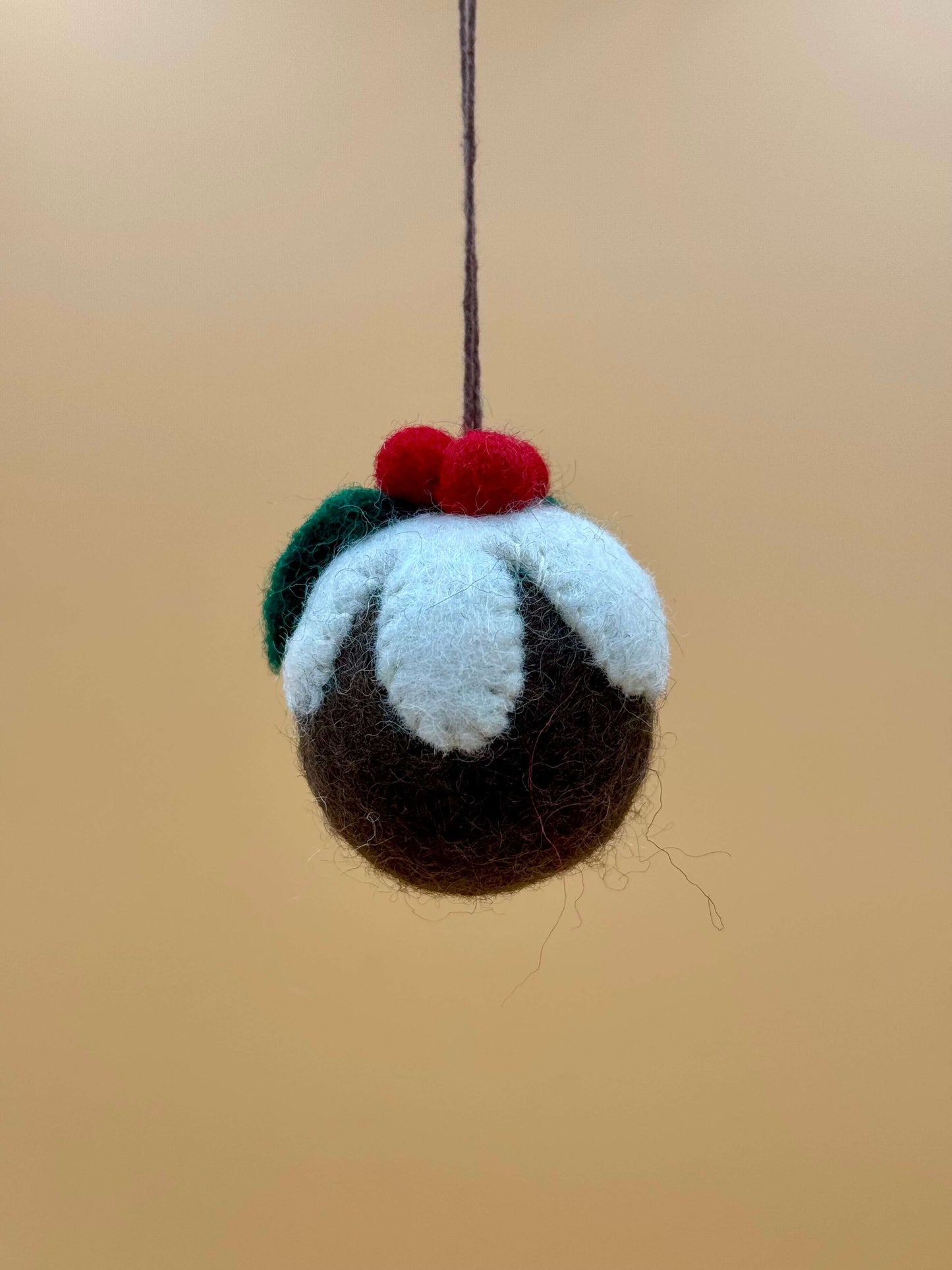 Handgemachter Filzanhänger in Form einer Weihnachtskugel, braun, grün und rot, ideal als Schlüsselanhänger oder Dekoration.
