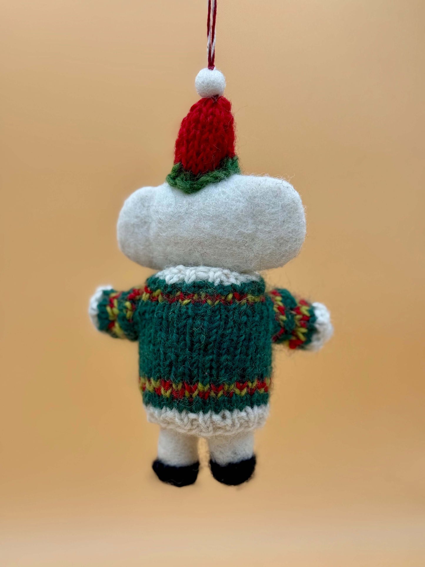 Handmade white and green felt keychain of a Christmas mouse, featuring a knitted sweater and hat on a beige background.