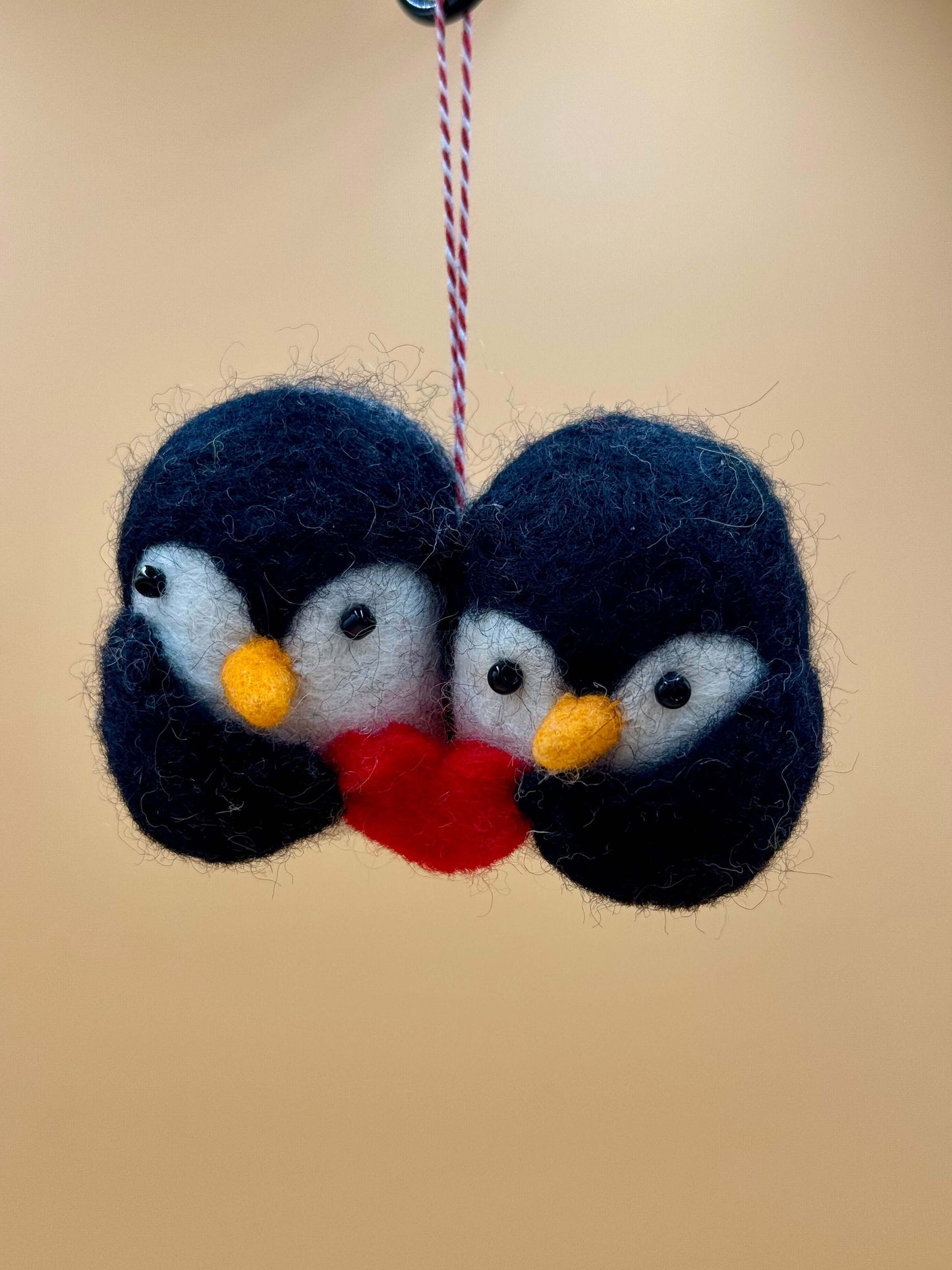 Handgemachter Filzanhänger mit zwei Pinguinen und Herz, ideal als Schlüsselanhänger aus 100% Wolle.