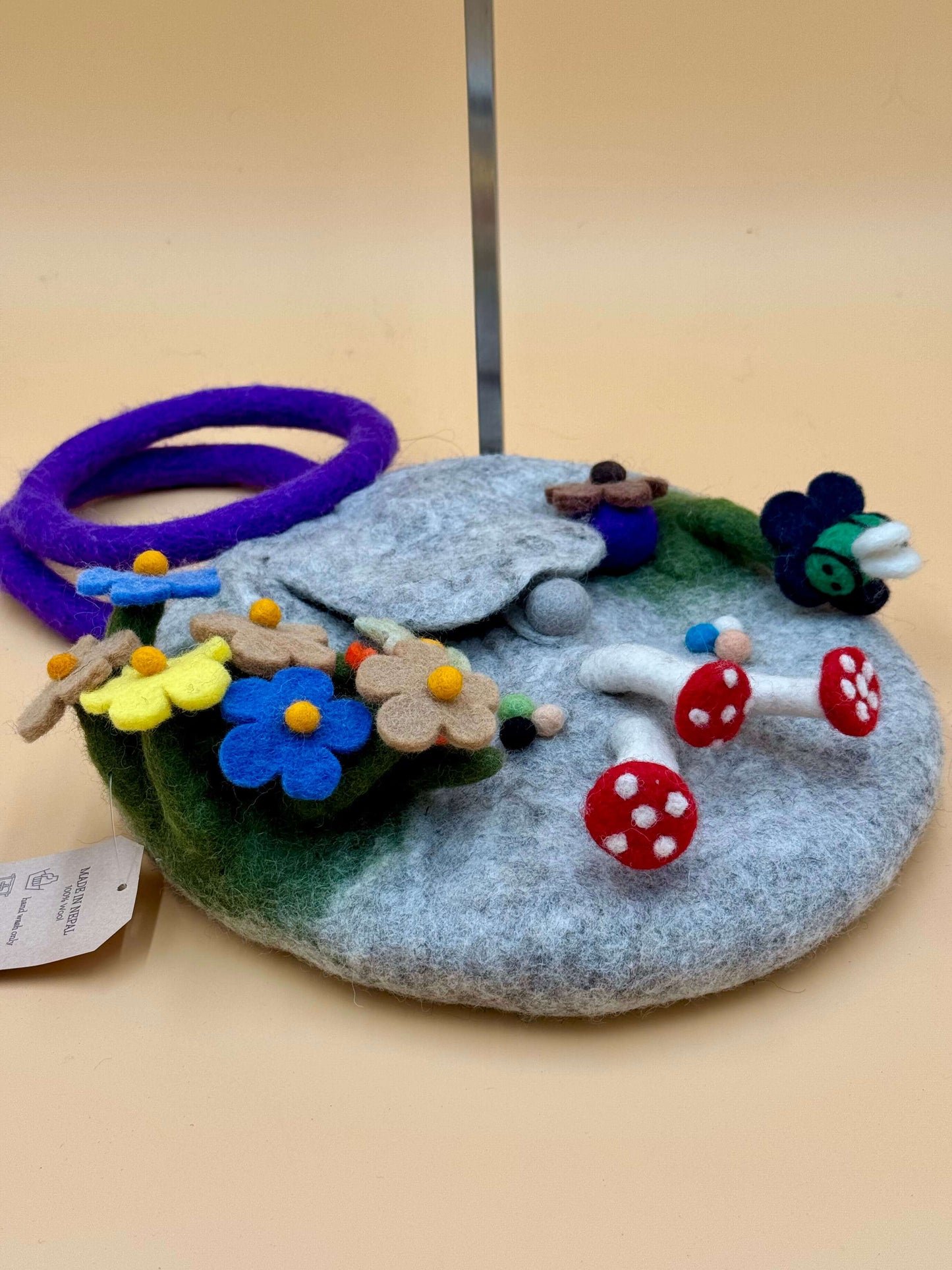 Handtasche Filztasche Size S Bucket Bag mit bunten Pilzen, Blumen und einem Ringgriff in grau und blau.