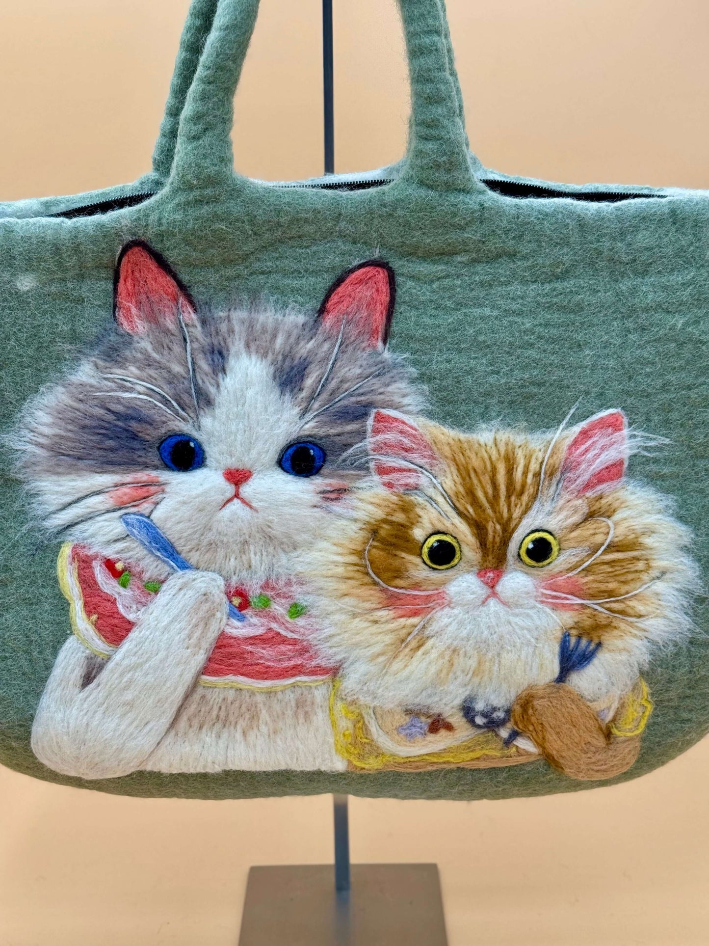 Handmade green felt bag featuring two cute cats, ideal for carrying everyday essentials.