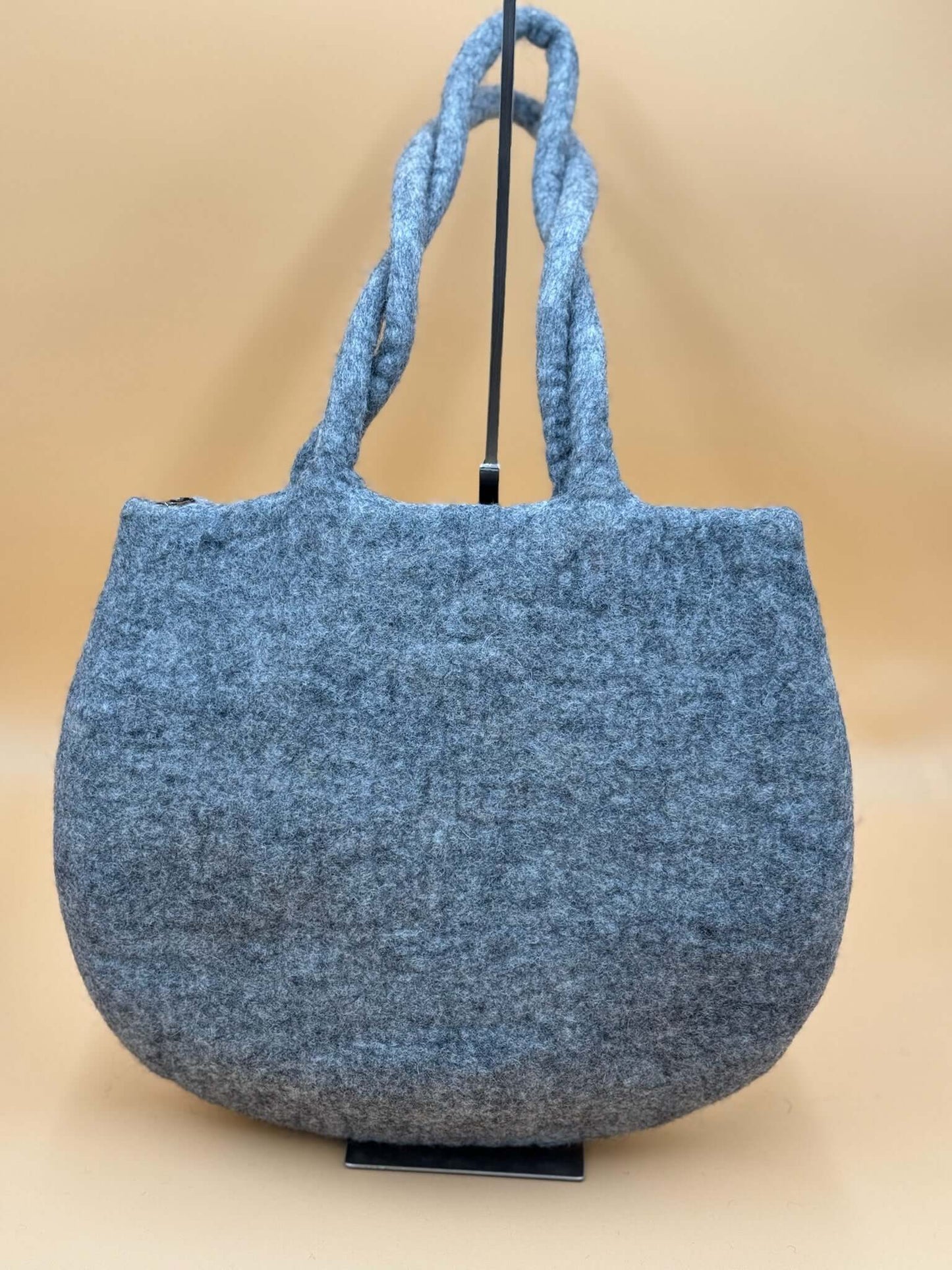 Gray handmade felt tote bag with braided handles, ideal for everyday use and carrying essentials.