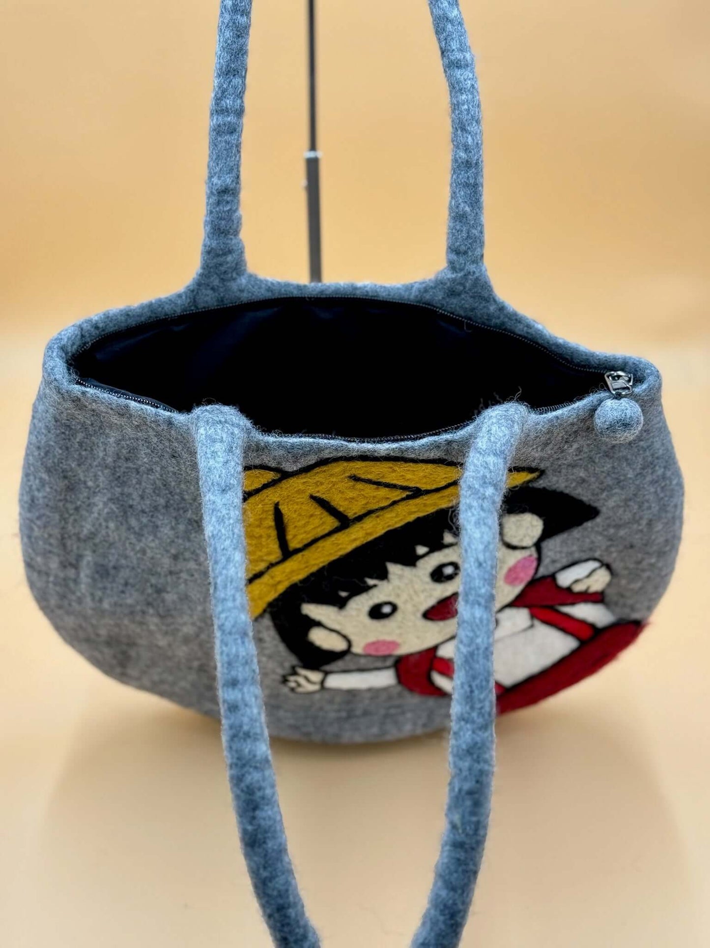 Handmade gray felt tote bag featuring a unique design, perfect for carrying daily essentials.