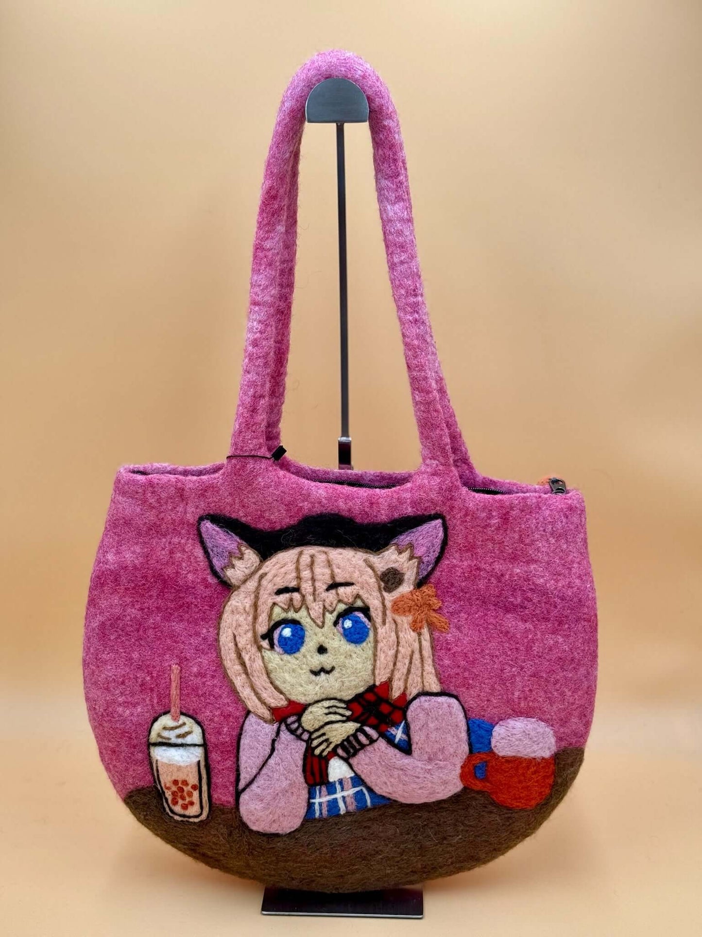 Handmade pink felt shoulder tote bag featuring an artistic character design and spacious layout.
