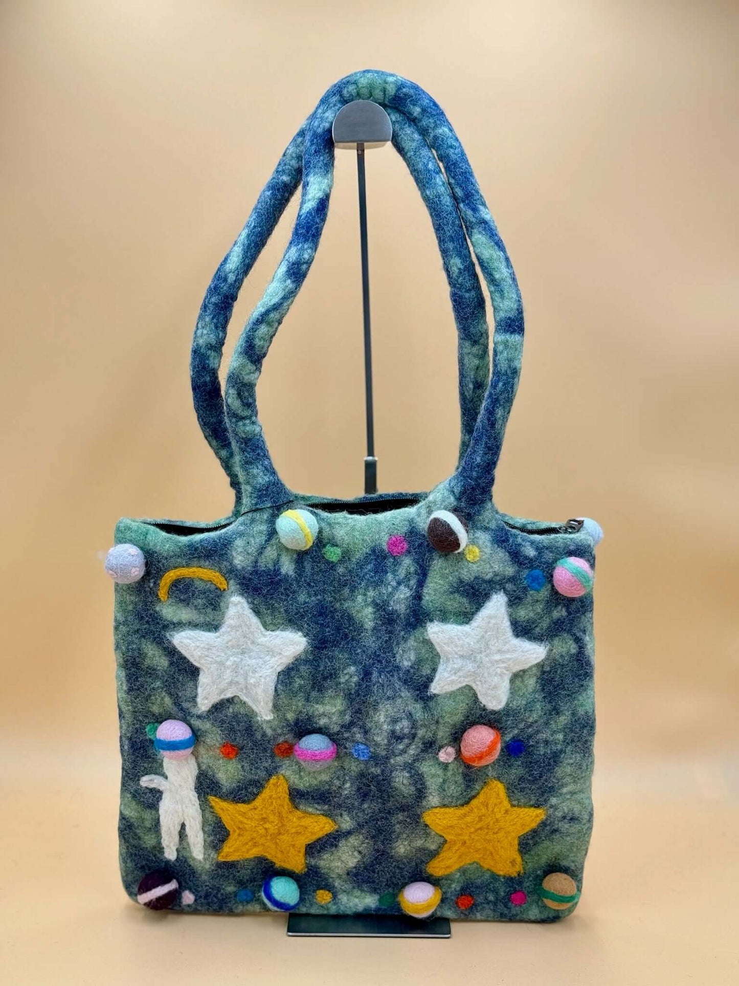Handgemachte grüne und blaue Filztasche Schultertasche mit bunten Planeten- und Sterne-Applikationen.