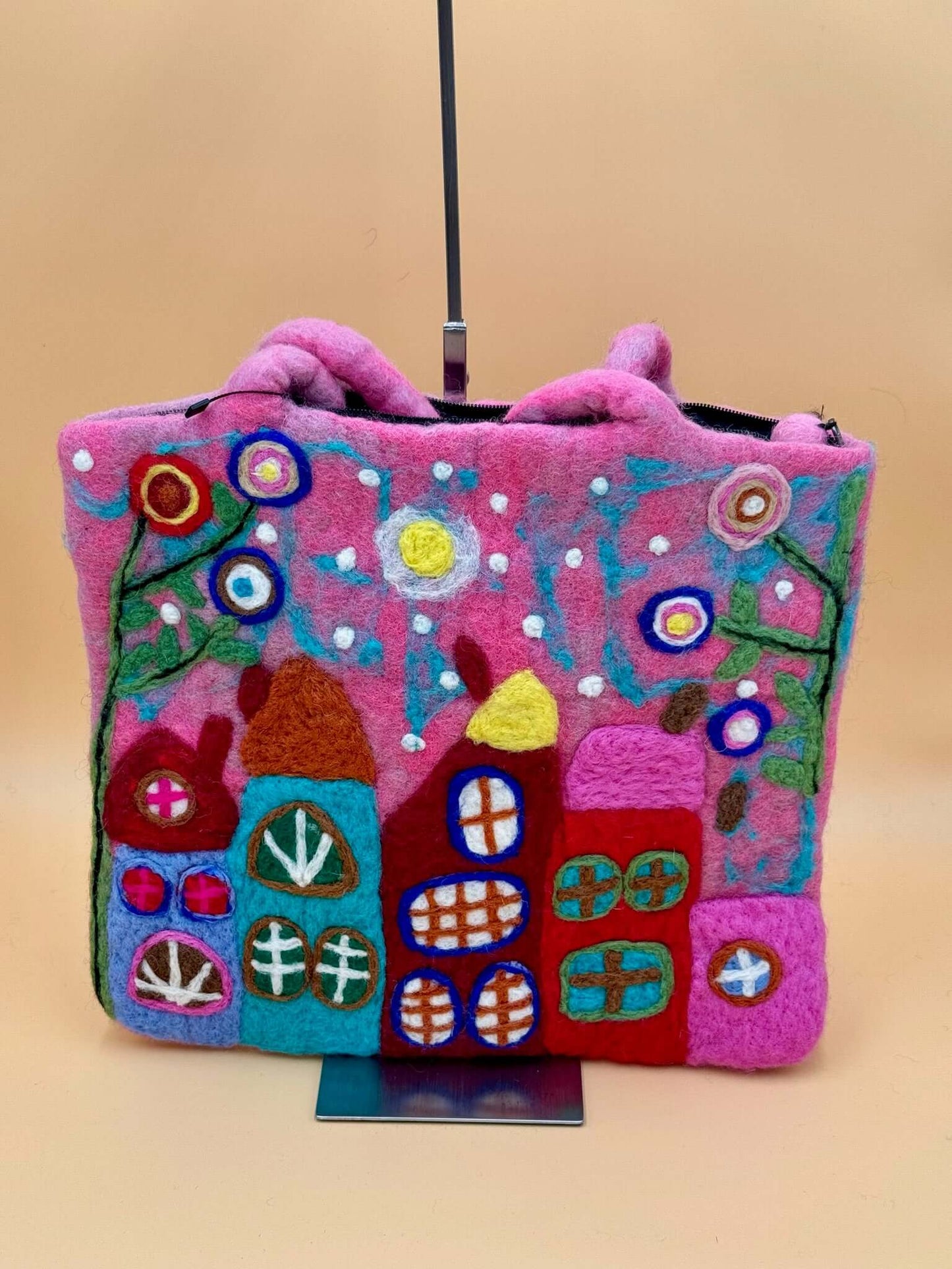 Handmade pink felt shoulder bag with colorful house design, perfect for carrying everyday essentials.