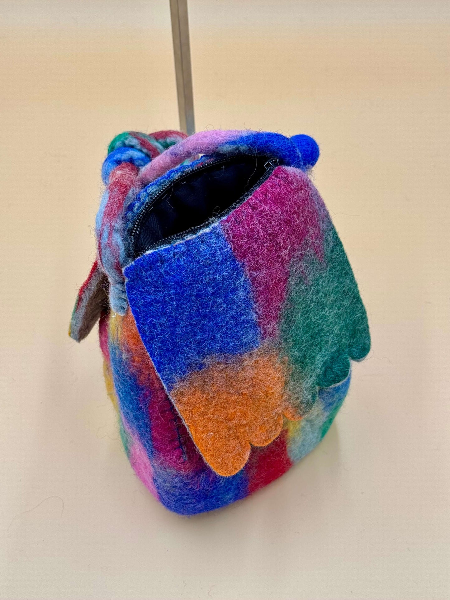 Umhängetasche Filztasche Size M in bunten Farben, handgefertigt aus Wolle mit Reißverschluss und Knopfdetails.