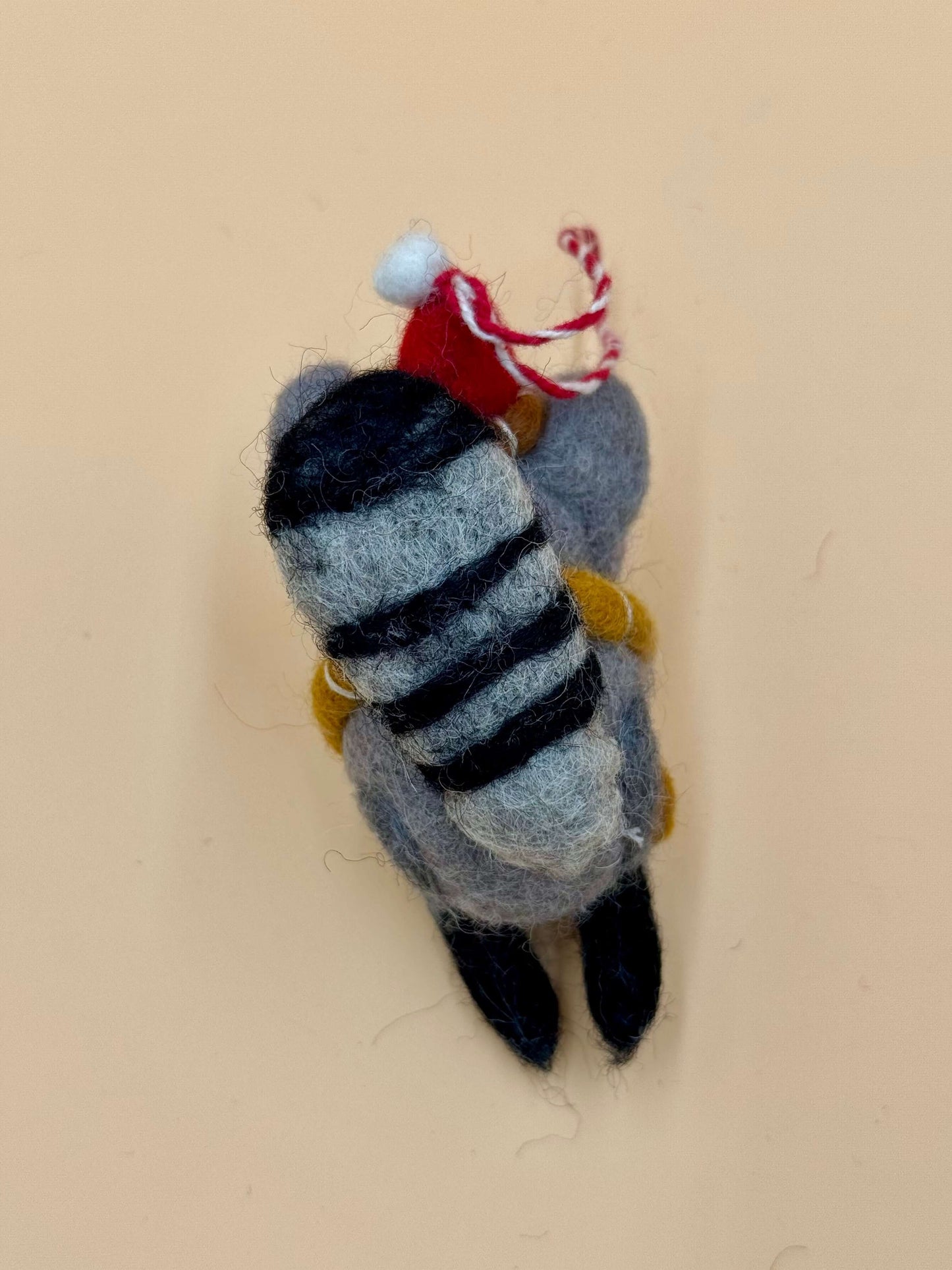 Filzanhänger Schlüsselanhänger Weihnachtswaschbär aus Wolle in grau, schwarz und rot, handgemacht mit Mütze und Schal.