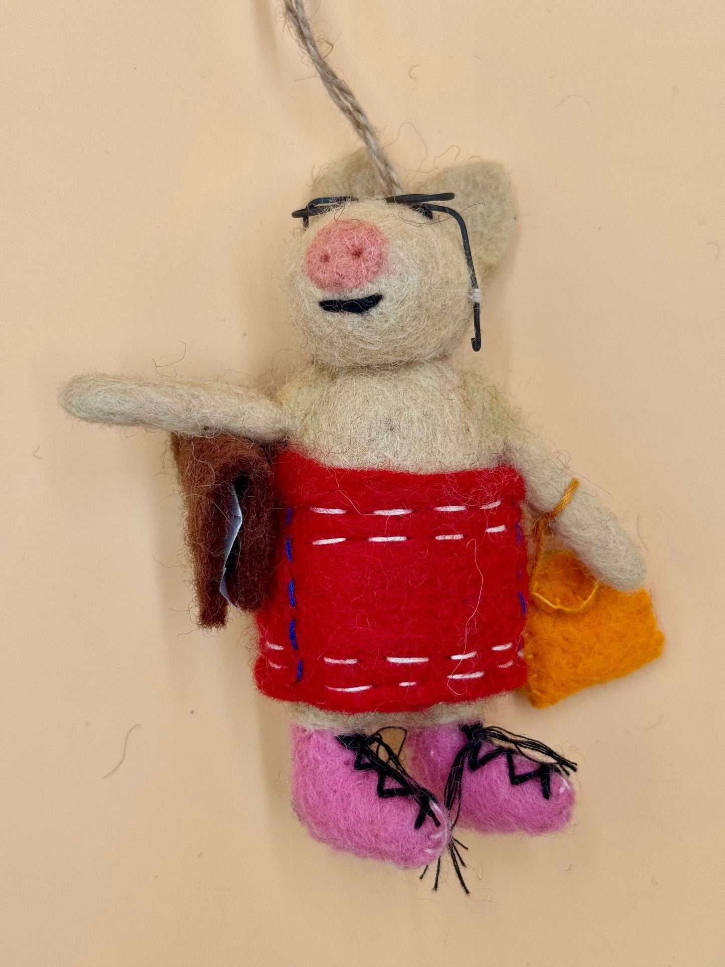 Handmade felt pig keychain in dress, glasses, and bag; unique accessory with vibrant colors.