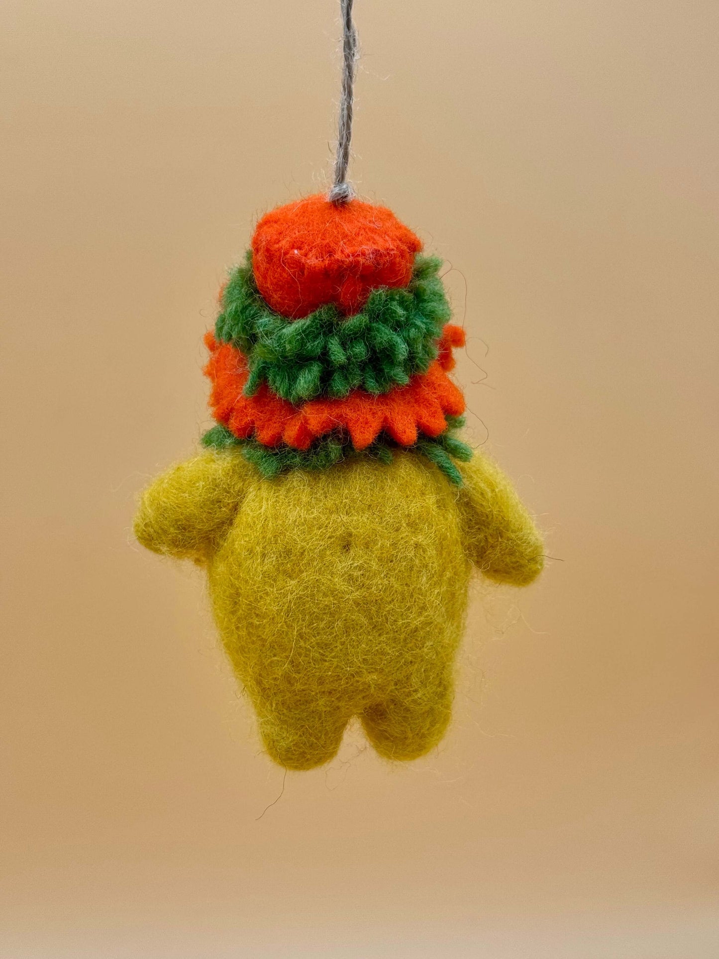 Handmade green and yellow felt keychain in the shape of a chicken, featuring a colorful hat.