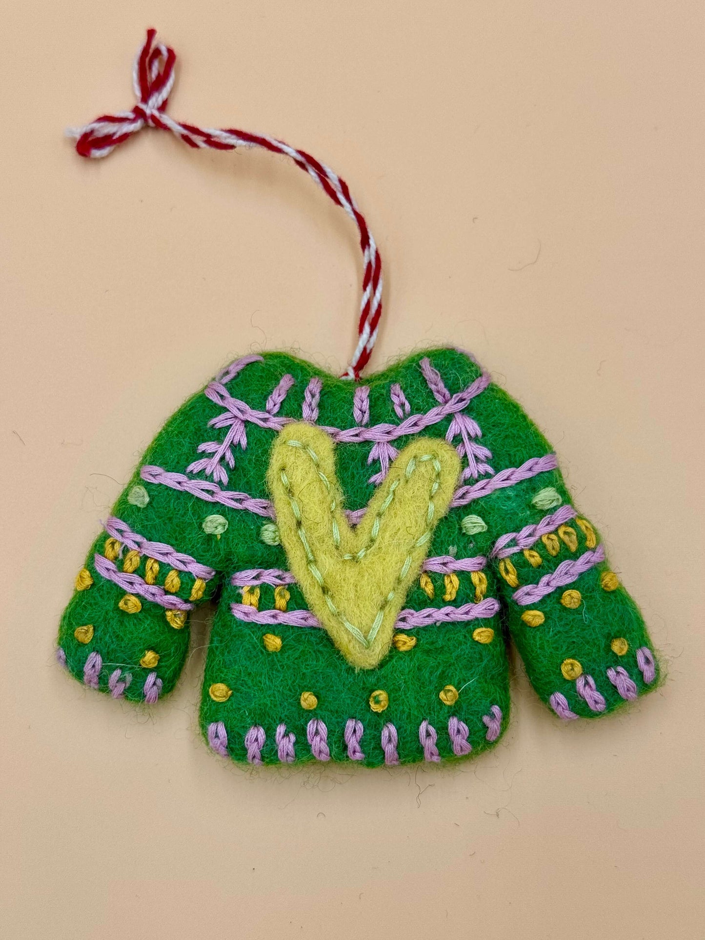 Handgemachter grüner Filz Schlüsselanhänger in Form eines Weihnachtspullovers mit bunten Verzierungen.