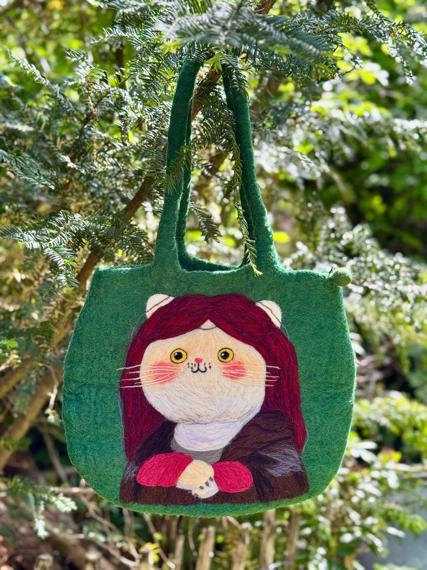 Handmade green felt tote bag featuring a cat with a Mona Lisa design, perfect for carrying personal items.