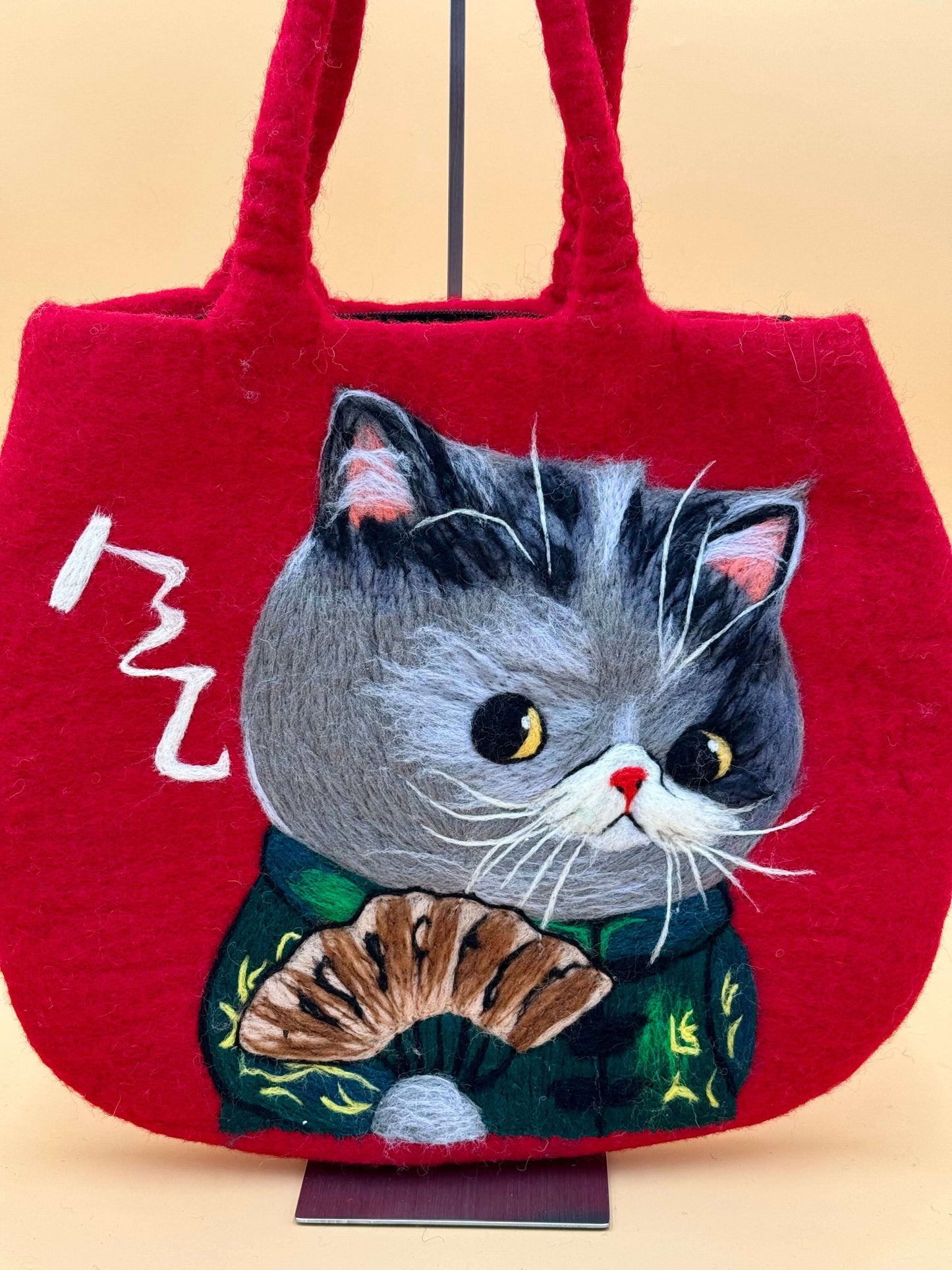 Handmade red felt shoulder bag featuring an embroidered cat design holding a fan, perfect for daily essentials.