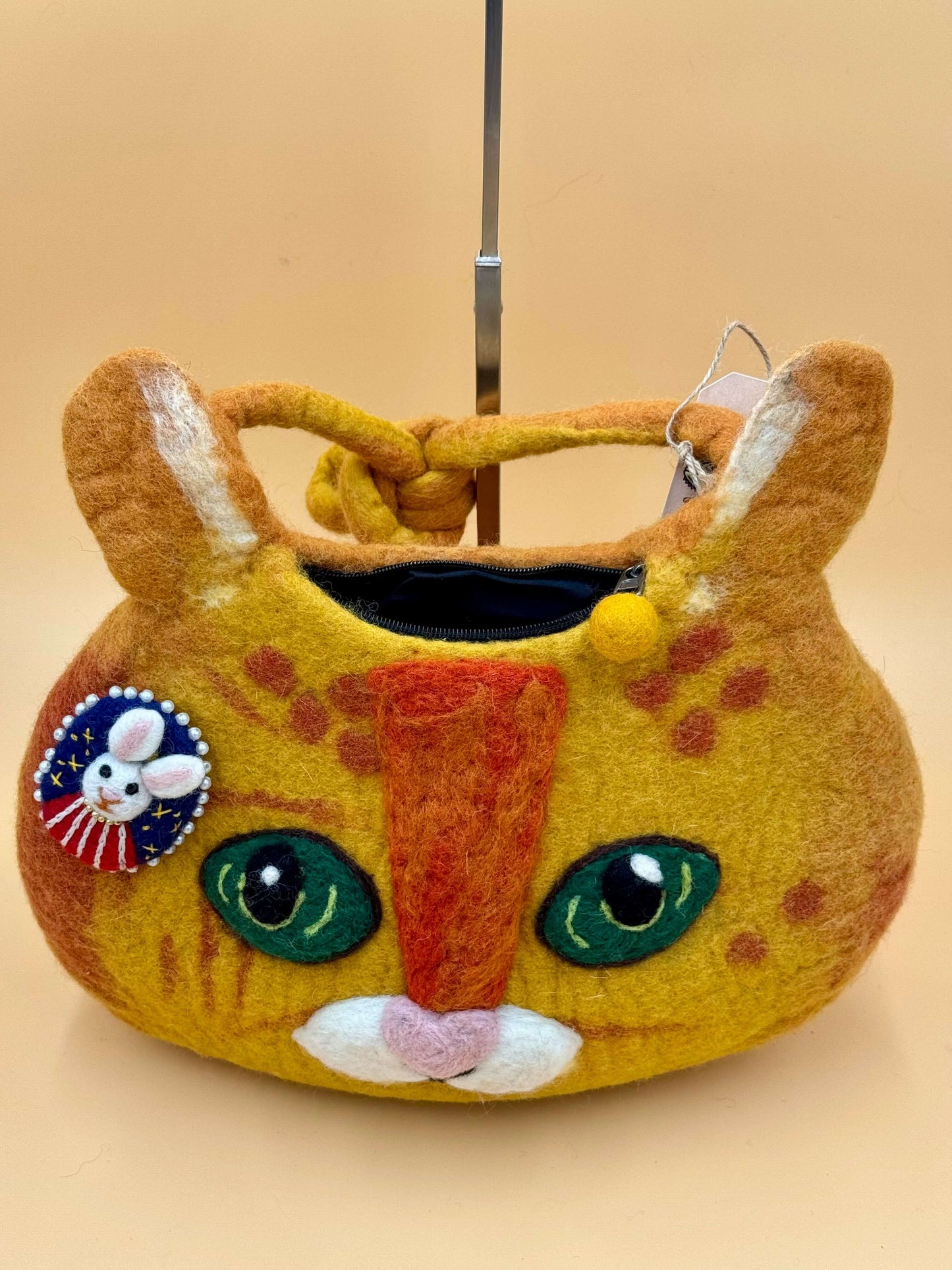 Handmade shoulder felt bag in cat design, orange-yellow, with decorative pin and inside zipper, perfect for daily use.