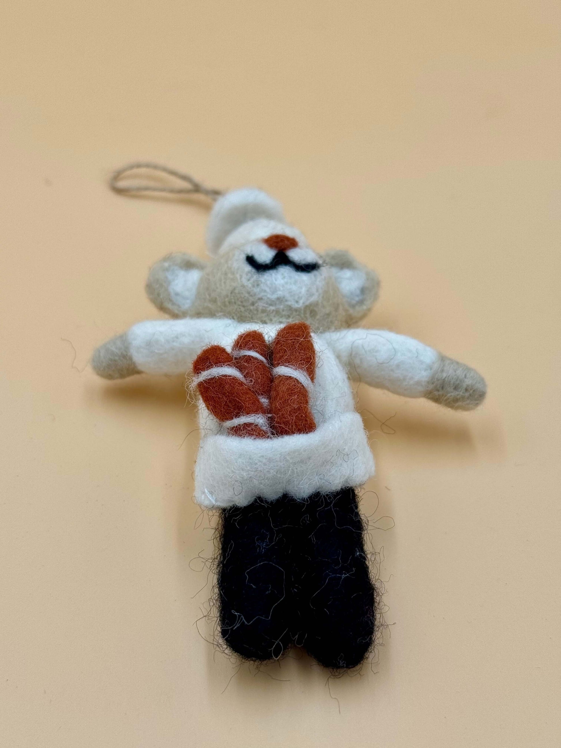 Handmade felt keychain of a bear baker with baguettes, brown and white, unique design, ideal for decoration.