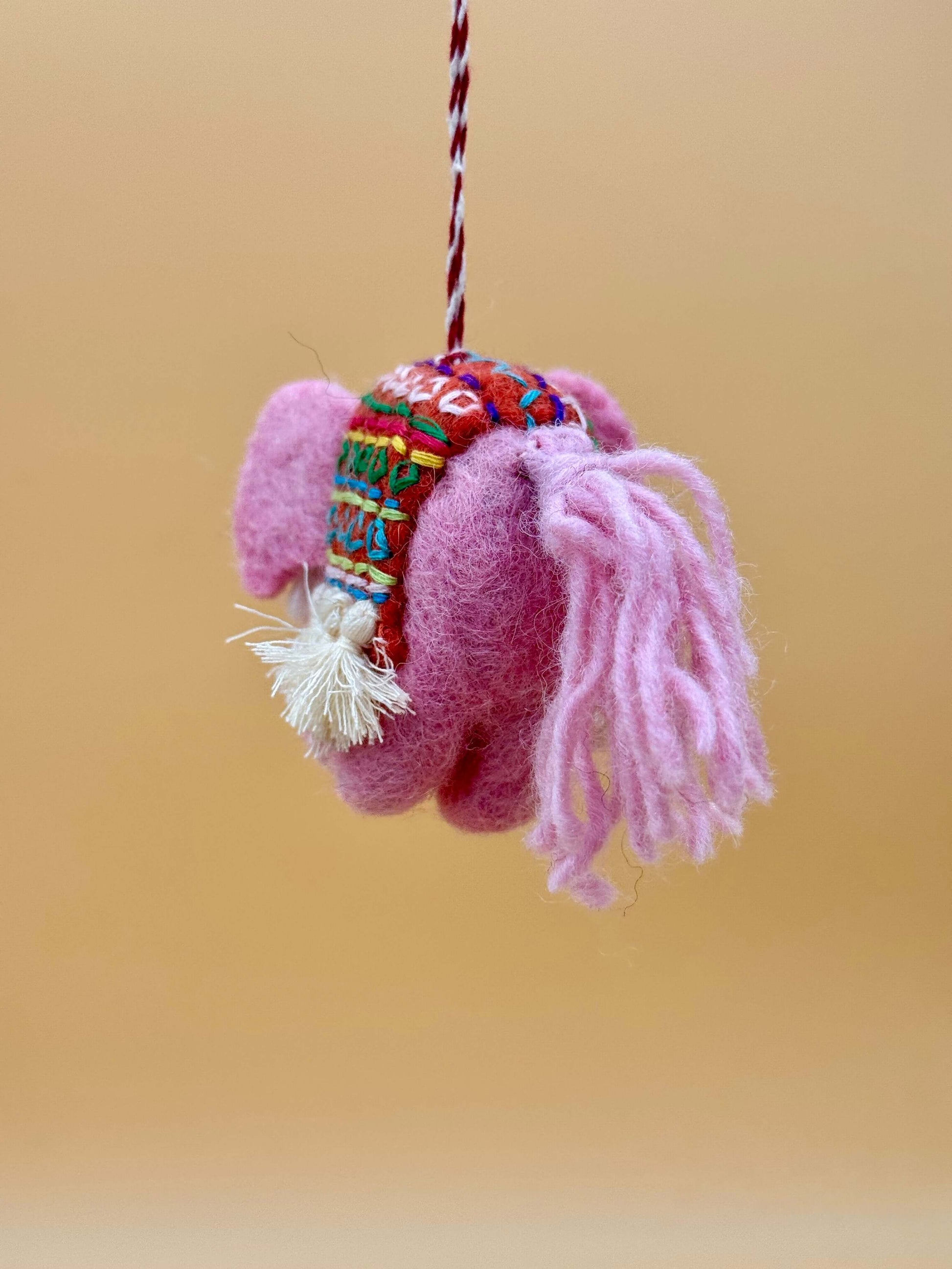 Handmade pink elephant felt keychain, featuring vibrant patterns and soft wool, perfect for decorative use.