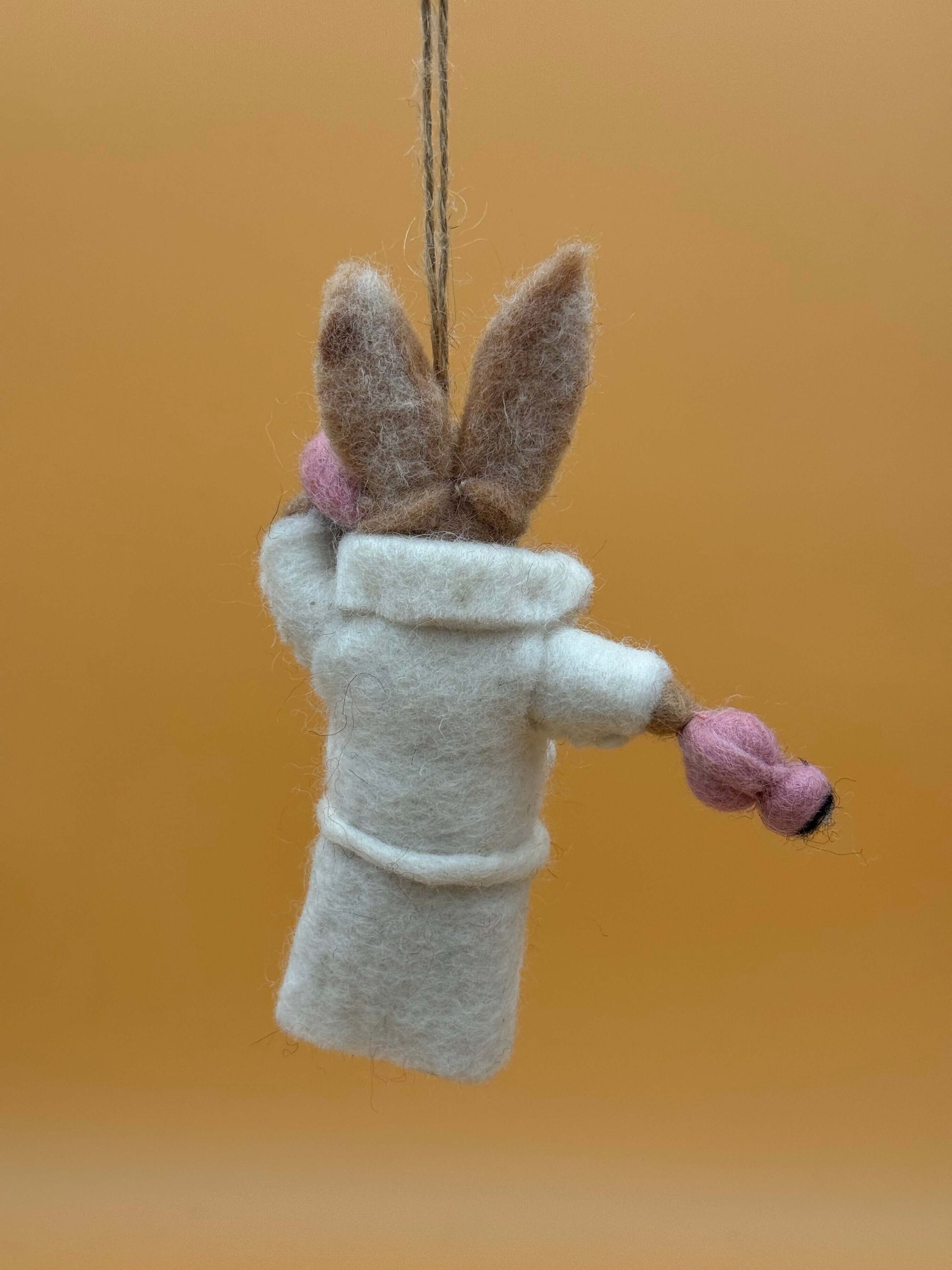 Filzanhänger Schlüsselanhänger Hase in Bademantel, handgemacht aus 100% Wolle, weiß mit rosa Details.