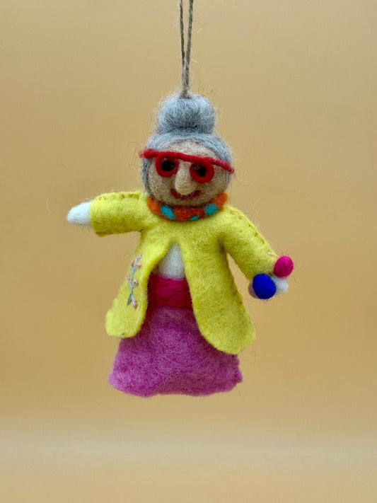Handmade wool felt keychain of a dancing grandma in yellow and pink attire, unique accessory for fashion lovers.