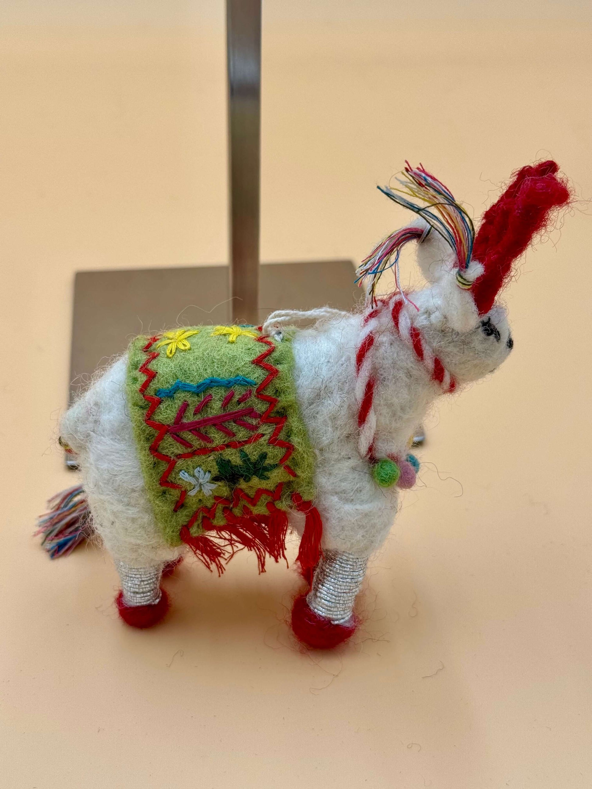 Handgemachter Filzanhänger als Schlüsselanhänger in Schaf-Form, weiß mit bunten Details, aus 100% Wolle gefertigt.