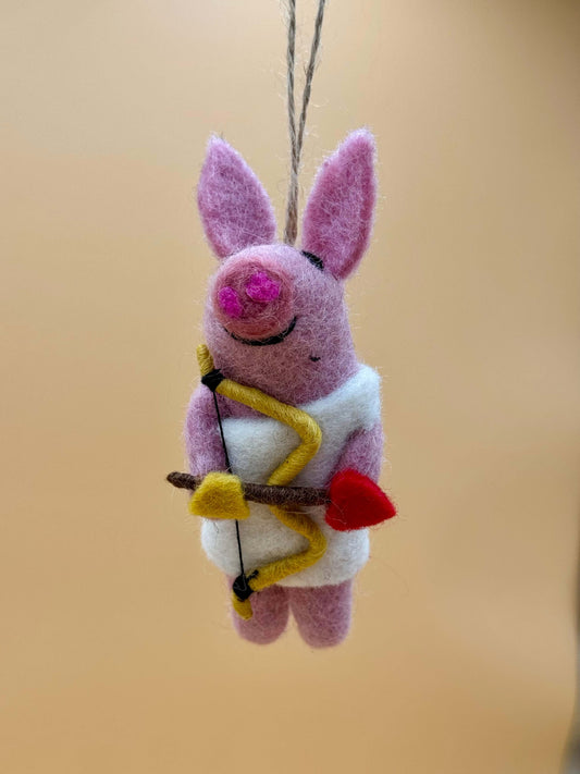 Handgemachter Filz-Schlüsselanhänger in Form eines Schweins mit Bogen und Pfeil, in pink und weiß.