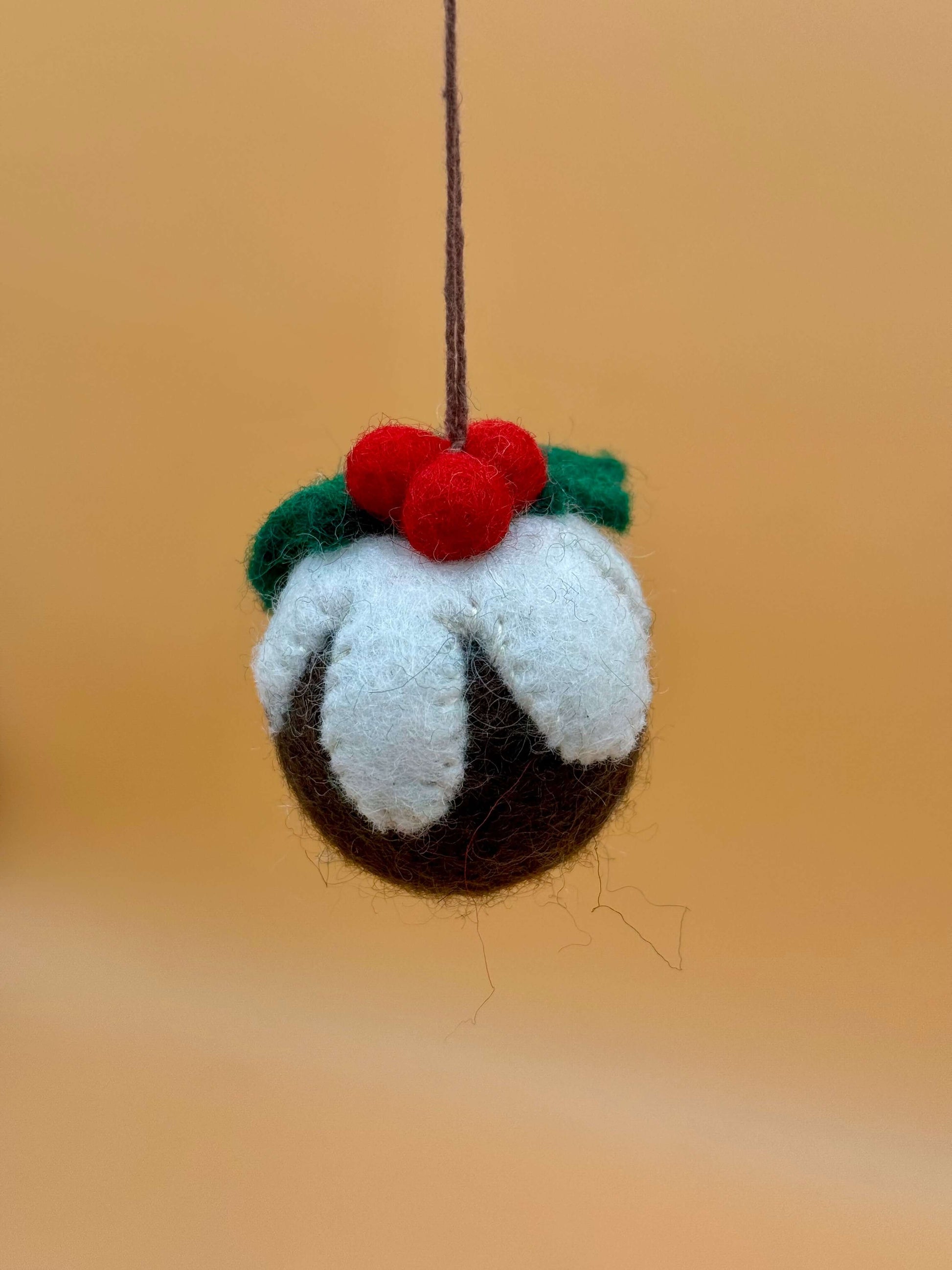 Handmade felt Christmas ornament featuring a cake design with red berries, ideal for festive tree decoration.