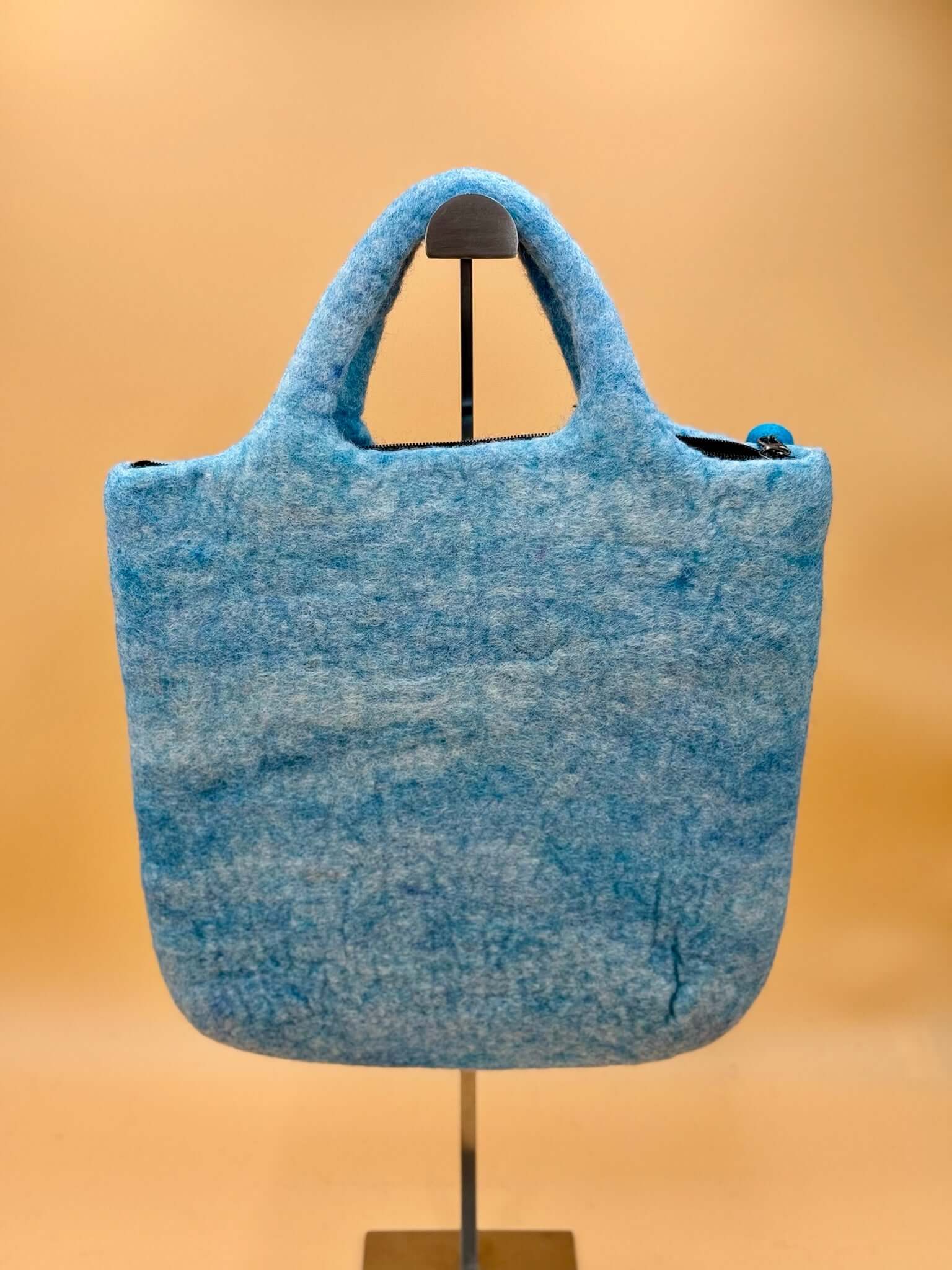 Handtasche Filztasche Size L Large Bag in blau, handgefertigt aus 100% Wolle, abgebildet auf Ständer.