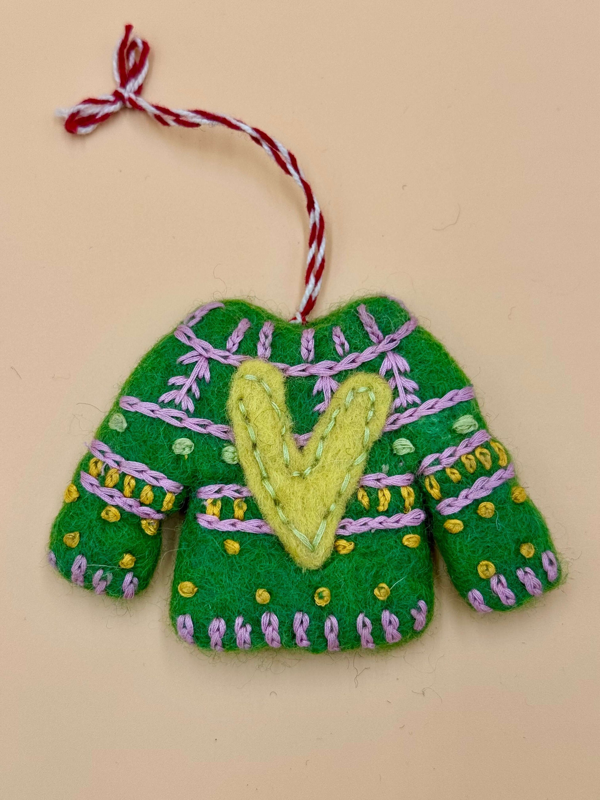 Handgemachter grüner Filz Schlüsselanhänger in Form eines Weihnachtspullovers mit bunten Verzierungen.